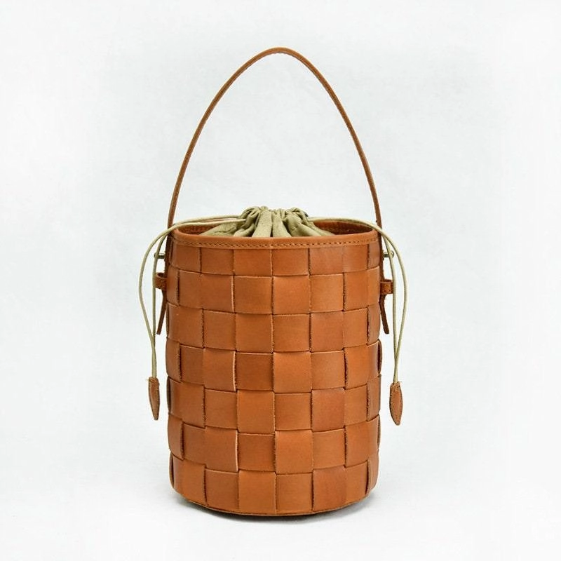 Sustainable fashion Polished Detail Woven Leather Bucket Bag In Tan, Handcrafted Woven Shoulder Bag, Woven Designer Bag, Handmade Shoulder Bag, Modern Leather Crossbody Bag